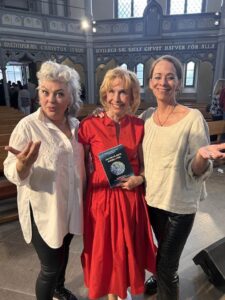 Musikduon Lise och Gertrud stod för underhållningen under Steve Sjöquists 70-årsfest. Mellan dem syns Sophie Ekman Wretlind med boken Jakten på sista pusselbiten, utgiven av Cladd Förlag i samarbete med Stiftelsen Läkare Mot AIDS Forskningsfond.
